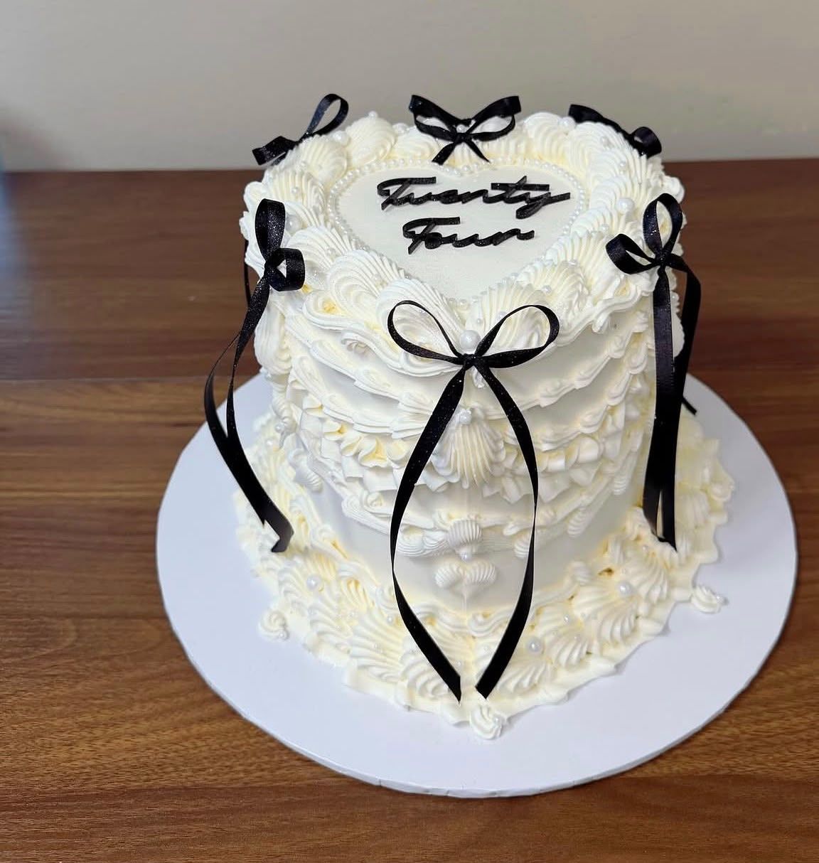 Tarta vintage en forma de corazón con ribetes de crema y lazos negros